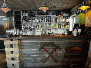 Gewehrmitnahme Pflicht wegen Eisbärengefahr. Theke nur mit alkoholischen Getränken („Until now no one has ordered water. Who are you?"). Drei Gäste in vier Stunden. Musik fast nur Leonard Cohen. Rückweg mit Luftschuss.